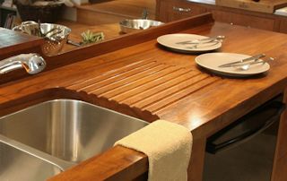 Teak face grain countertop including an integrated sloping drainboard for an undermount sink.