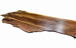 Custom wood island top made from book-matched walnut slabs. The bookmatched slabs form the main part of an island top along with a smaller slab used to achieve the final shape.  Wane edge and waterlox satin finish.
