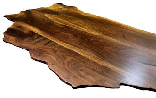 Custom wood island top made from book-matched walnut slabs. The bookmatched slabs form the main part of an island top along with a smaller slab used to achieve the final shape.  Wane edge and waterlox satin finish.