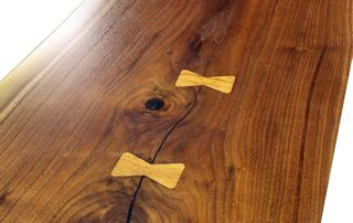 Custom Walnut slab table top with maple butterfly inlays. Natural edges and Waterlox satin finish