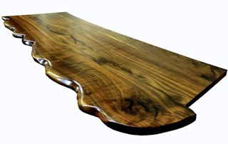 One section of a multi-section walnut slab bar top.  sculpted wane edge and waterlox semi-gloss finish.