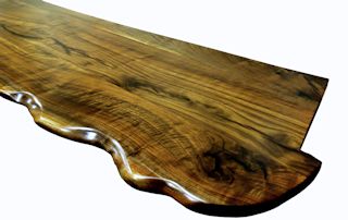 One section of a multi-section walnut slab bar top.  sculpted wane edge and waterlox semi-gloss finish.