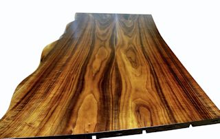 One section of a multi-section walnut slab bar top.  Using book-matched slabs with a sculpted wane edge and waterlox semi-gloss finish.