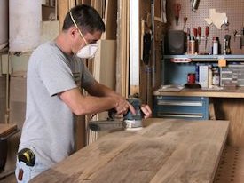 Finish sanding a small walnut island top