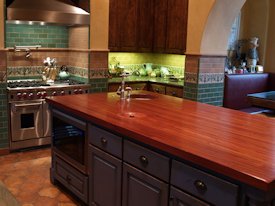 Jatoba edge grain custom wood island countertop with hand carved trash cover.