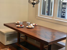 Custom Banquette Table.  Constructed using Slab Guanacaste with a Face Grain Walnut Band and a Custom Walnut Table Base.  Waterlox Satin Finish.