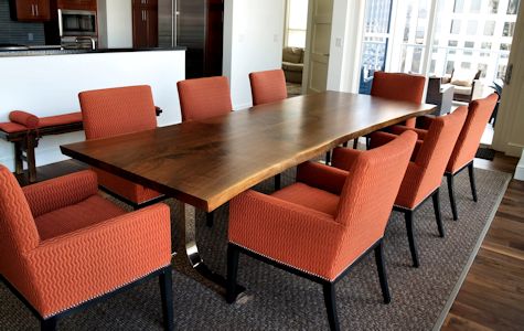 Custom walnut slab table top with wane edges and a handmade mirror polished bronze base.