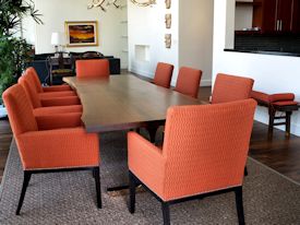 Custom dining table using walnut slabs with wane edges on a custom handmade mirror polished bronze base.