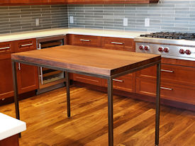 Custom Face Grain Walnut table with Tung-Oil Finish and a custom flat black metal base.