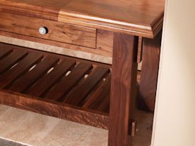 Custom walnut table with false drawer fronts and slat style shelf.