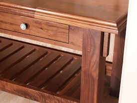 Custom walnut table with false drawer fronts and slat style shelf.