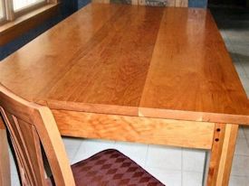 Custom Cherry shaker style dining table with drawer and walnut accents on legs.