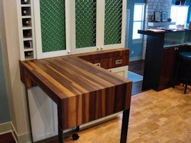 Custom rolling walnut table with partial returns with a mitre joint on a flat metal base.  With a custom matching drawer cabinet.