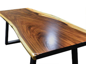 Custom dining table using a Guanacaste Slab Top with Natural Edges and Waterlox Satin finish.  Custom flat black metal base.