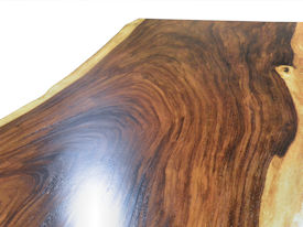 Custom dining table using a Guanacaste Slab Top with Natural Edges and Waterlox Satin finish.  Custom flat black metal base.