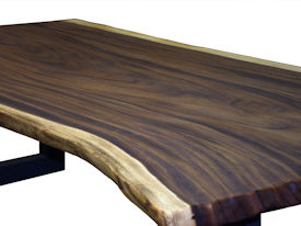 Custom dining table using a Guanacaste Slab Top with Natural Edges and Tung Oil Citrus finish.  Custom flat black metal base.