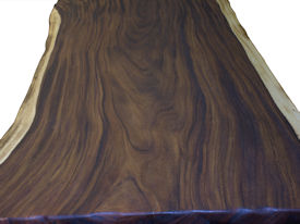 Custom dining table using a Guanacaste Slab Top with Natural Edges and Tung Oil Citrus finish.  Custom flat black metal base.