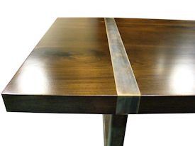Custom dining table using book-matched walnut slabs with a drop edge for the top.  Custom steel base and accent bands with a hand rubbed (bronze) finish.