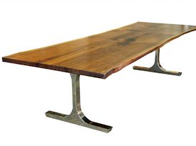 Custom dining table using walnut slabs with wane edges on a custom handmade mirror polished bronze base.