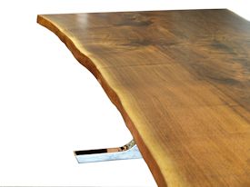 Custom dining table using walnut slabs with wane edges on a custom handmade mirror polished bronze base.
