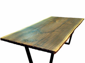 Custom Walnut Bookmatched Slab Table with Natural Edges, a Tung-Oil Finish and a flat black metal base. 