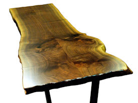Custom Walnut Bookmatched Slab Table with Natural Edges, a Waterlox Finish and a flat black metal base. 