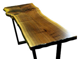 Custom Walnut Bookmatched Slab Table with Natural Edges, a Waterlox Finish and a flat black metal base. 