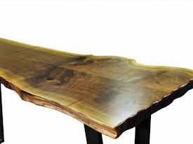 Custom Walnut Bookmatched Slab Table with Natural Edges, a Waterlox Finish and a flat black metal base. 