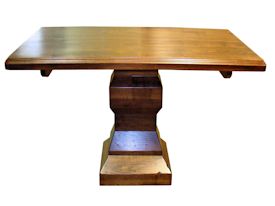 Custom distressed walnut table with pedestal-style base.