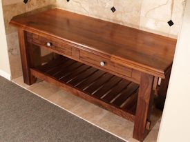 Custom walnut table with false drawer fronts and slat style shelf.