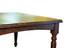 Custom distressed Walnut dining table with custom designed turned legs and arched aprons.