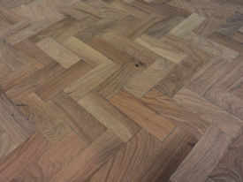 Distressed herringbone mesquite trestle-style dining table with Walnut banding and Walnut leaves.  Through mortise and tenon jointery.  Custom Stain.